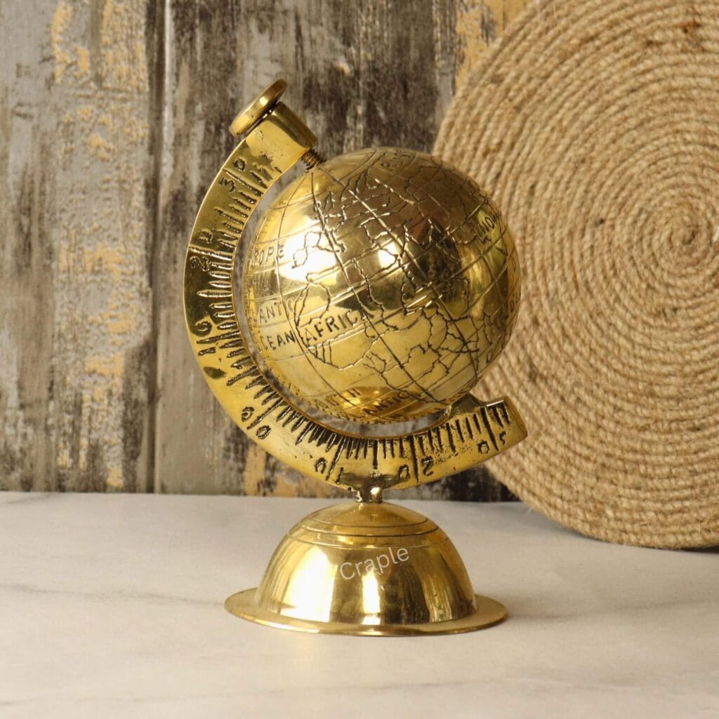 Handmade decorative desktop globe made of solid brass with a shiny finish, showing an engraved world map.