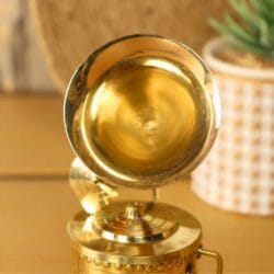 Close-up of the polished brass horn and soundbox on a handmade decorative miniature gramophone.