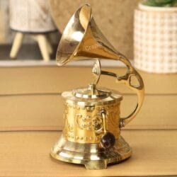 Side profile of a vintage-style brass gramophone showcasing the intricate embossed floral patterns on its base.