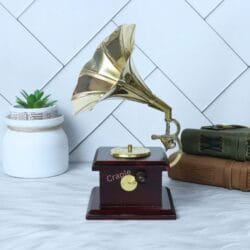 Side view of a vintage-style miniature phonograph replica showing the hand crank and wooden base.