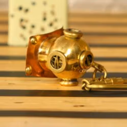 Side profile of the miniature brass diving helmet keychain, showing the authentic replica details and secure clip.
