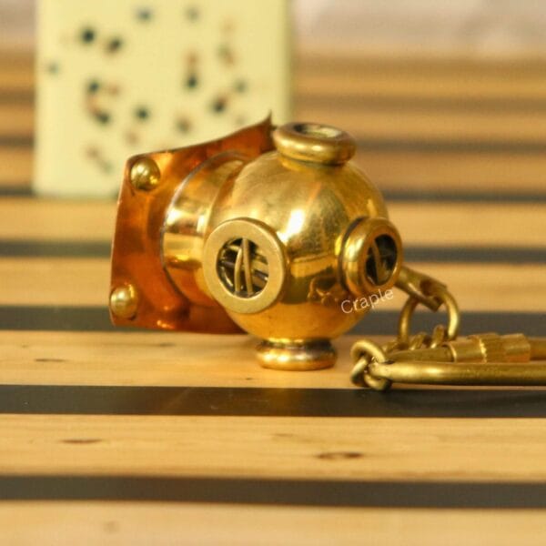 Side profile of the miniature brass diving helmet keychain, showing the authentic replica details and secure clip.