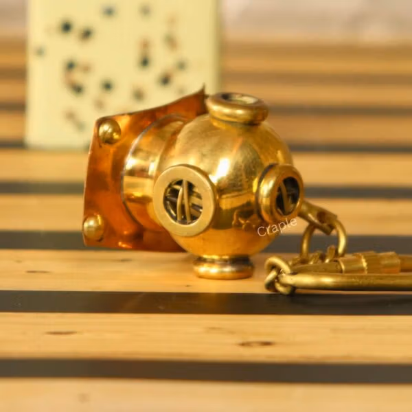 Side profile of the miniature brass diving helmet keychain, showing the authentic replica details and secure clip.