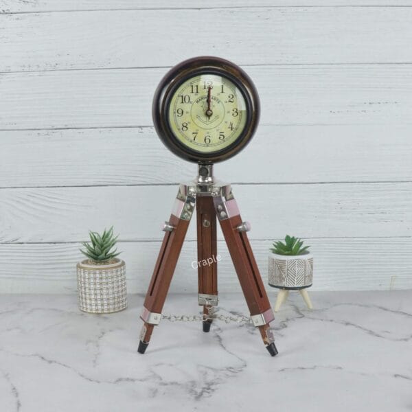 Handmade vintage table clock on a wooden tripod stand with an antique finish and a classic analog face.