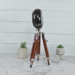 Side profile of the vintage tripod clock, highlighting the depth of the clock and the polished nickel hardware on the wooden legs.