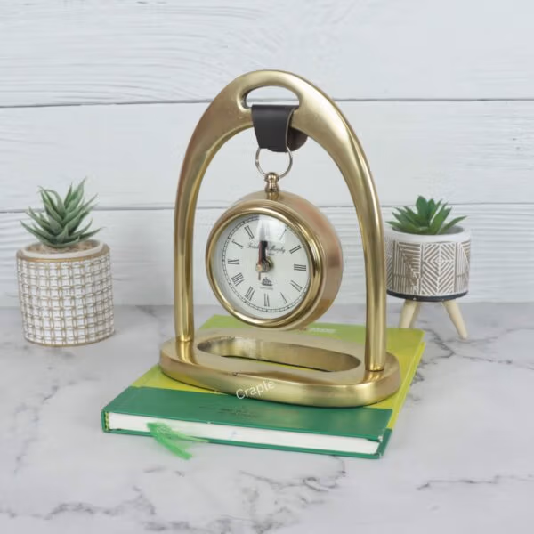 Angled view of the golden hanging desk clock resting on a book, displayed as a stylish office accessory.