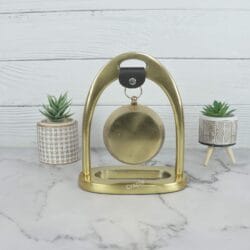 Back view of the golden aluminum desk clock, showing the solid construction of the arch stand and the rear of the clock.