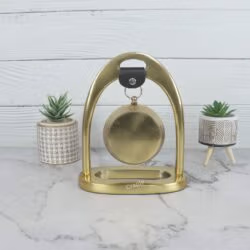 Back view of the golden aluminum desk clock, showing the solid construction of the arch stand and the rear of the clock.