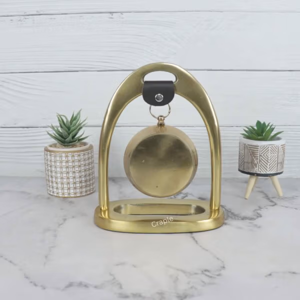 Back view of the golden aluminum desk clock, showing the solid construction of the arch stand and the rear of the clock.