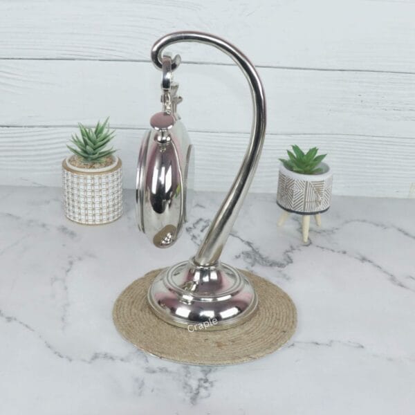 Angled side view of the nickel finish tabletop clock, highlighting the reflective surface of the stand and casing.