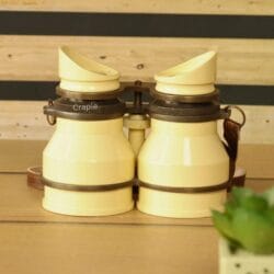Stacked retro light yellow aluminum binoculars with leather straps – collectible decorative binoculars or unique gift idea.