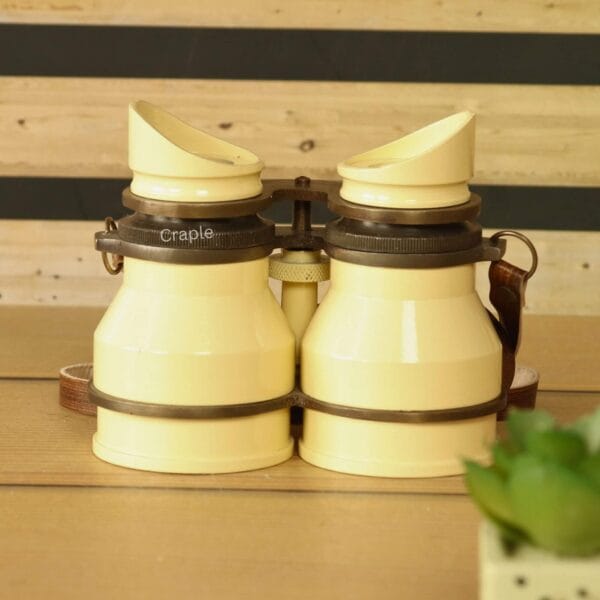 Stacked retro light yellow aluminum binoculars with leather straps – collectible decorative binoculars or unique gift idea.
