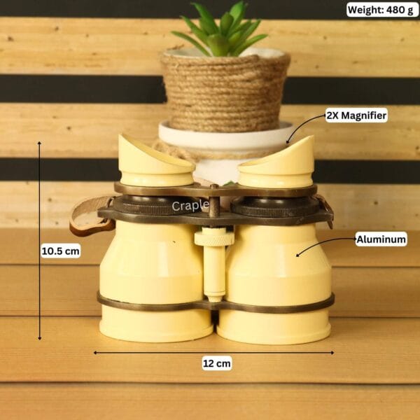 Light yellow aluminum binoculars with angled eyecups and leather strap showing labeled dimensions 12 cm width, 10.5 cm height, 480 g weight, 2x magnifier – retro decorative binoculars for home decor or unique gift.