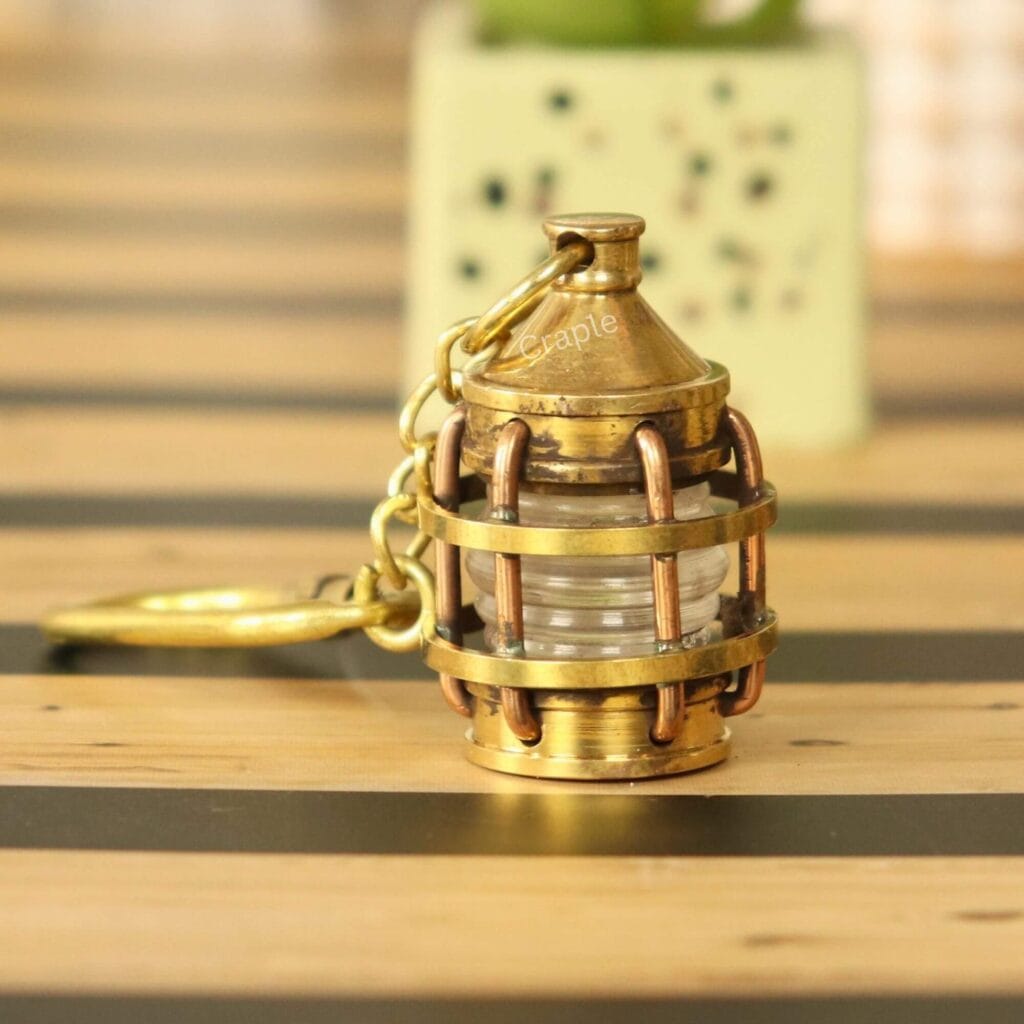 Miniature nautical lantern keychain made from solid brass with a shiny finish and a secure carabiner clip.