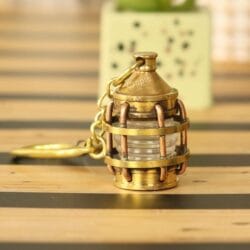 Miniature nautical lantern keychain made from solid brass with a shiny finish and a secure carabiner clip.