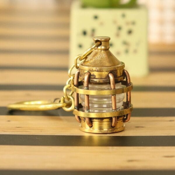 Miniature nautical lantern keychain made from solid brass with a shiny finish and a secure carabiner clip.
