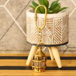 The miniature lantern keychain hanging from a decorative pot, showcasing its use as a stylish accessory.