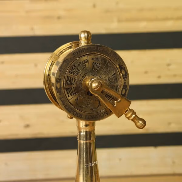 Close-up angled view of the brass telegraph's dial and handle, showing the detailed engraved commands like 'Full Ahead'.