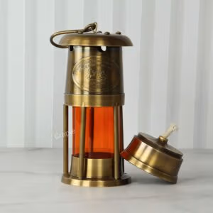 Antique brass nautical lantern with its functional oil lamp base removed to show the cotton wick.