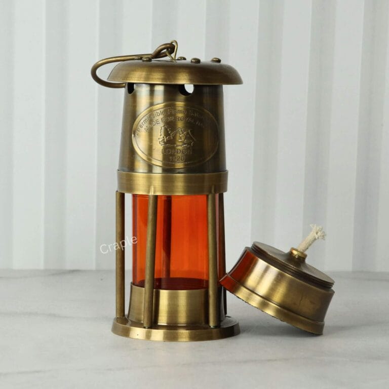 Antique brass nautical lantern with its functional oil lamp base removed to show the cotton wick.