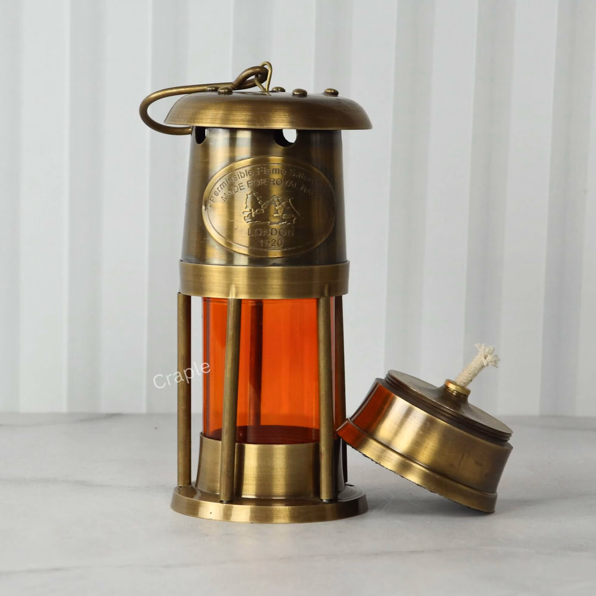 Antique brass nautical lantern with its functional oil lamp base removed to show the cotton wick.