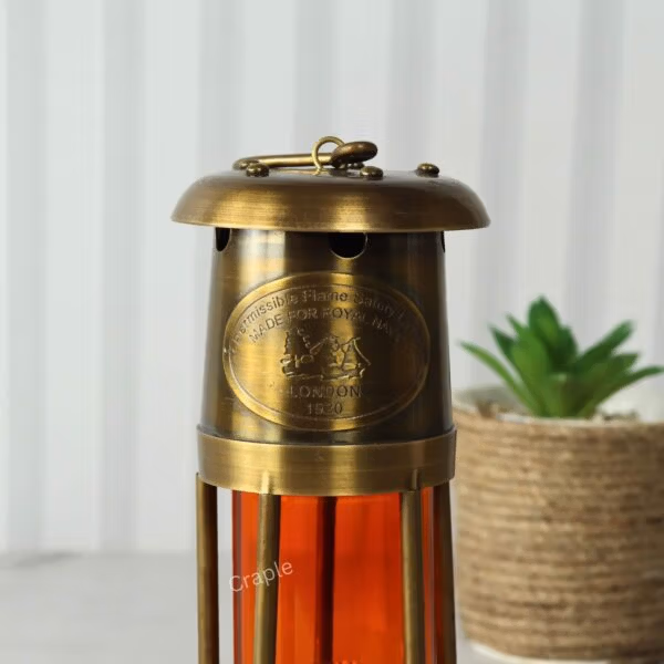 The brass nautical lantern used as a decorative piece for maritime-themed home decor, placed next to a plant.