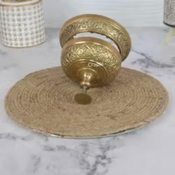 Close-up of the disassembled brass bell, showcasing the intricate floral engraving on the dome and base.