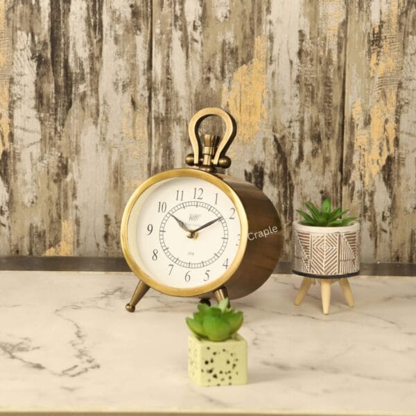 Angled side view of the vintage oval tabletop clock, showing the depth of its antique-finished aluminum case.