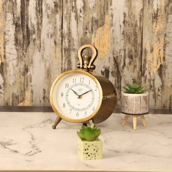 Angled side view of the vintage oval tabletop clock, showing the depth of its antique-finished aluminum case.