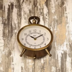 The versatile antique oval clock shown hanging on a rustic wooden wall by its decorative top handle.