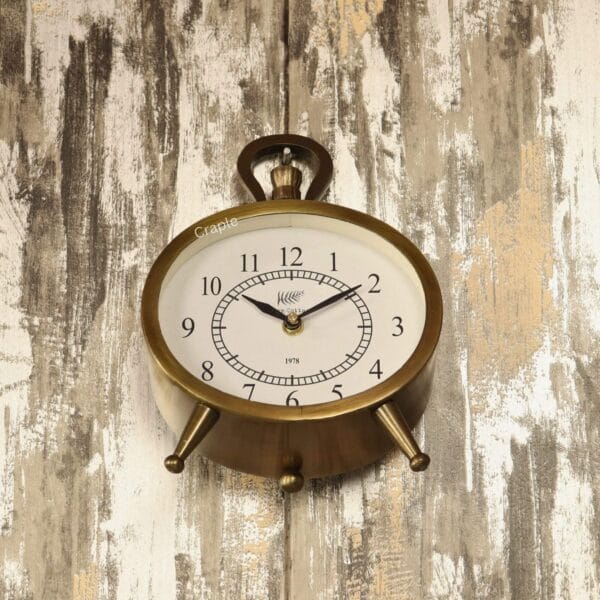 The versatile antique oval clock shown hanging on a rustic wooden wall by its decorative top handle.