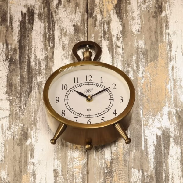 The versatile antique oval clock shown hanging on a rustic wooden wall by its decorative top handle.