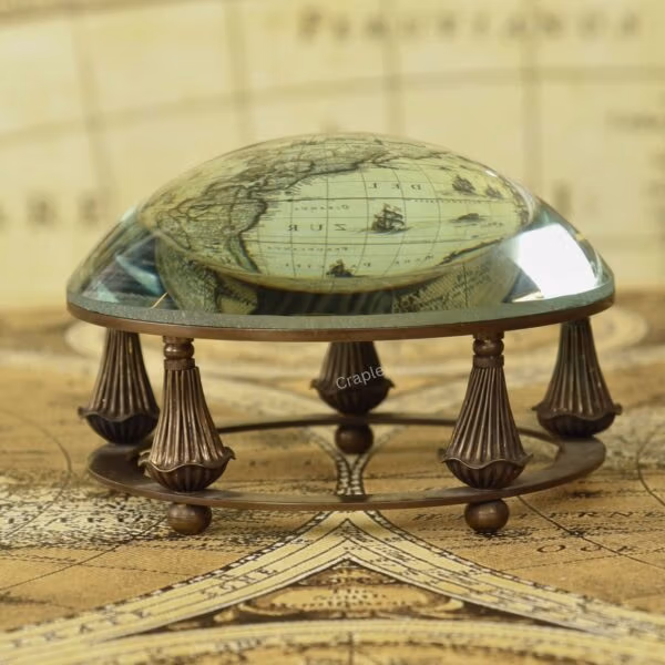 Paperweight Brass Desk Magnifier-1 Antique brass desk magnifier and paperweight with a glass dome lens resting in a decorative gimbal stand on a vintage map.