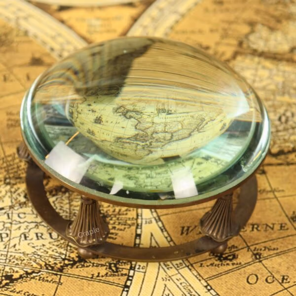 Paperweight Brass Desk Magnifier-2 A close-up of the glass dome paperweight magnifier enlarging the details of an antique world map.