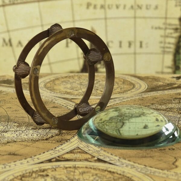 The two-piece desk set showing the glass dome magnifier placed next to its antique-finish brass gimbal holder.