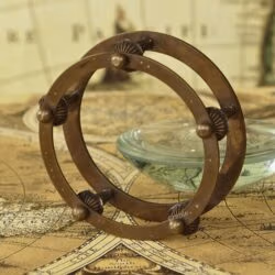 Detailed close-up of the intricate design and antique finish on the brass armillary-style stand.