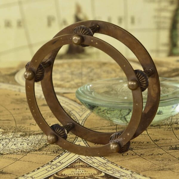 Detailed close-up of the intricate design and antique finish on the brass armillary-style stand.