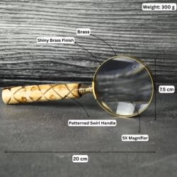 Brass magnifier with labeled specifications: 20 cm length, 7.5 cm lens, 300g weight, and 5X magnification.