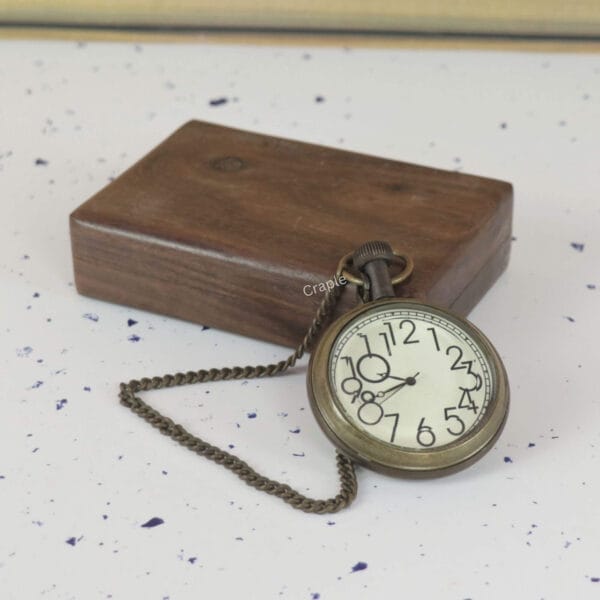 Vintage-style brass pocket watch and chain shown alongside its closed wooden storage box.