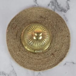 Top-down view of the golden brass service bell, showing the detailed fluted pattern on the dome and the push-button.