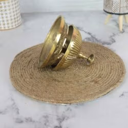 The brass reception bell tilted on its side, displaying the separate dome and engraved base.