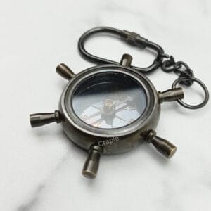 Nautical shipwheel compass keychain made from solid brass with a black antique finish and a secure carabiner clip.