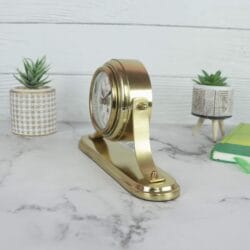 Rear angled view of the golden desk clock, displaying the solid aluminum casing and the pivoting hinge design.