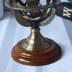 Close-up of the polished wooden base and antique brass stand of the small celestial armillary sphere.