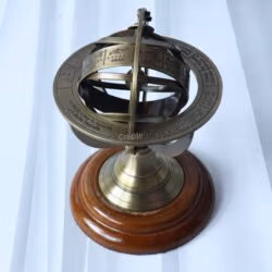 High-angle view of the tabletop armillary sphere, showing the engraved celestial rings and brass construction.