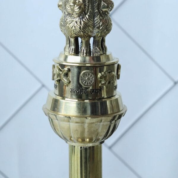 Detailed close-up of the Lion Capital of Sarnath on the brass Ashoka Pillar, showing the intricate carvings.