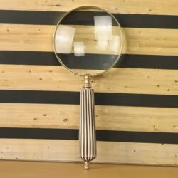 Elegant handheld magnifying glass with 5X magnification, a polished brass frame, and a vintage black and white striped handle.