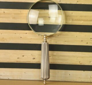 Elegant handheld magnifying glass with 5X magnification, a polished brass frame, and a vintage black and white striped handle.