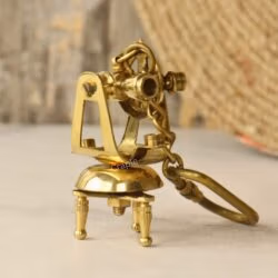 Detailed miniature brass theodolite keychain, designed as a vintage surveyor's transit with a stable tripod base and secure clip.