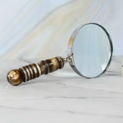 Close-up view of the intricately turned resin handle and the sturdy nickel-plated frame of a reading magnifier.
